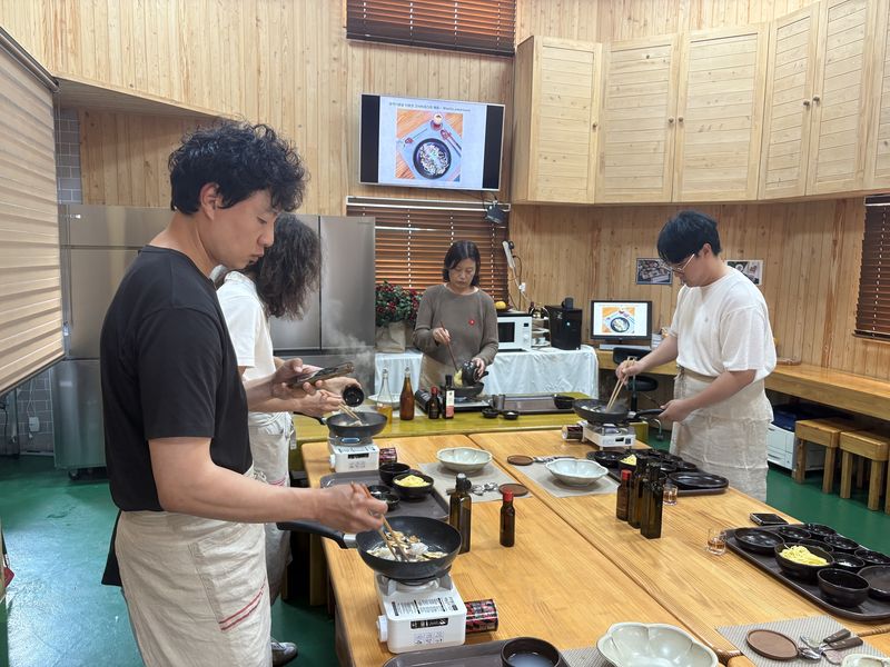 국내 럭셔리 관광객 유치 전문 여행사 관계자들이 서귀포시 남원읍 동백마을에서 동백오일과 제주 고사리를 활용한 파스타를 만들고 있다. 제주도와 제주관광공사는 지역 생산자원과 체험을 연결해 체류가치와 지역소비를 높이는 관광상품으로 개발할 계획이다. /사진=제주관광공사 제공