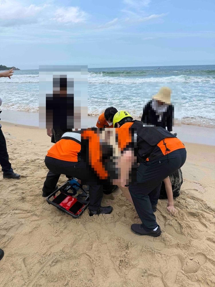 [고성=뉴시스] 26일 강원 고성군 화진포 콘도 앞에서 아이 2명이 해상에 표류되어 구조중이던 성인 남성 2명이 의식이 없는 상태로 구조돼 119구급대가 응근조치에 나서고 있다.(사진=강원도소방본부 제공)photo@newsis.com *재판매 및 DB 금지