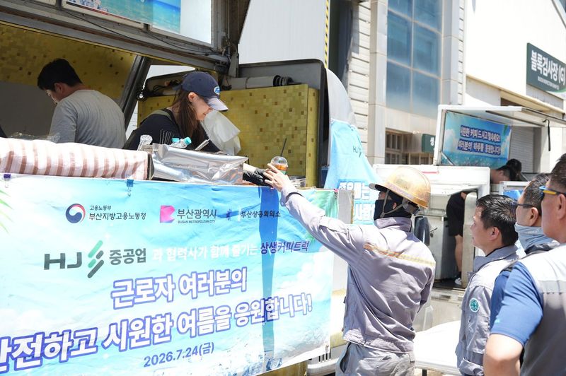 지난 24일 HJ중공업 구내식당 앞에 마련된 커피트럭에서 HJ중공업과 협력사 근로자들이 커피를 나눠받고 있다. 부산상의 제공