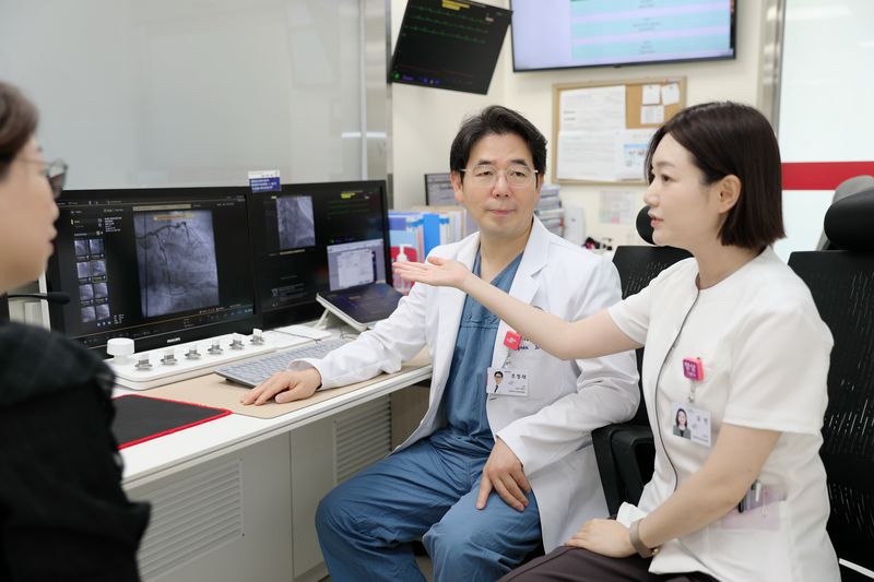 [서울=뉴시스] 조정래 한림대학교강남성심병원 교수에게 스텐트 시술을 받은 중국인 환자의 보호자에게 모빈 의료전문코디네이터가 시술 경과와 치료 과정을 중국어로 설명하고 있다. (사진= 한림대학교강남성심병원 제공)