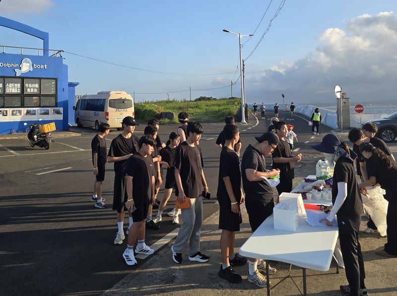 우도중학교 학생들이 지난 20일 ‘건강한 우도 한 바퀴’ 참가자들에게 행사 물품을 나눠주고 있다. 학생들은 총괄관리·안전보건·홍보디자인·콘텐츠운영팀으로 역할을 나눠 행사 전 과정을 이끌었다. /사진=우도중학교 제공