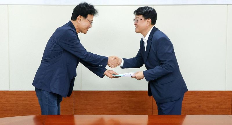 [대전=뉴시스] 백서를 전달받는 오석진(오른쪽) 대전시교육감. (사진=대전시교육청 제공) 2026.07.27. photo@newsis.com *재판매 및 DB 금지