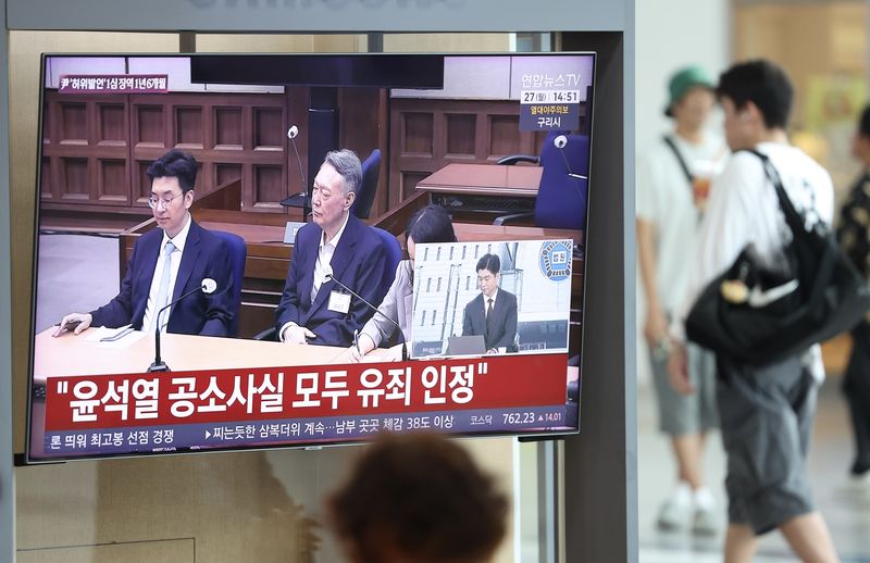 [서울=뉴시스] 김명년 기자 = 윤석열 전 대통령이 지난 1년 동안 17억여원에 달하는 영치금을 받은 것으로 전해졌다. 이는 현직 대통령 연봉의 6배를 웃도는 액수다. 대선후보 시절 건진법사 전성배 씨에 관한 허위사실을 공표한 혐의로 기소된 윤석열 전 대통령 1심 선고 공판이 열린 지난 27일 서울역에서 시민들이 관련 방송을 지켜보고 있다. 이날 재판부는 윤 전 대통령에게 징역 1년 6개월에 집행유예 3년을 선고했다. 2026.07.28. kmn@newsis.com