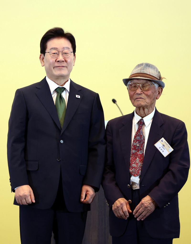 [상파울루=뉴시스] 김진아 기자 = 이재명 대통령이 28일(현지 시간) 브라질 상파울루의 한 호텔에서 열린 동포 오찬 간담회에서 마지막 생존 전쟁포로인 임관택 씨에게 감사패를 전달하고 기념 촬영을 하고 있다. 2026.07.29. bluesoda@newsis.com