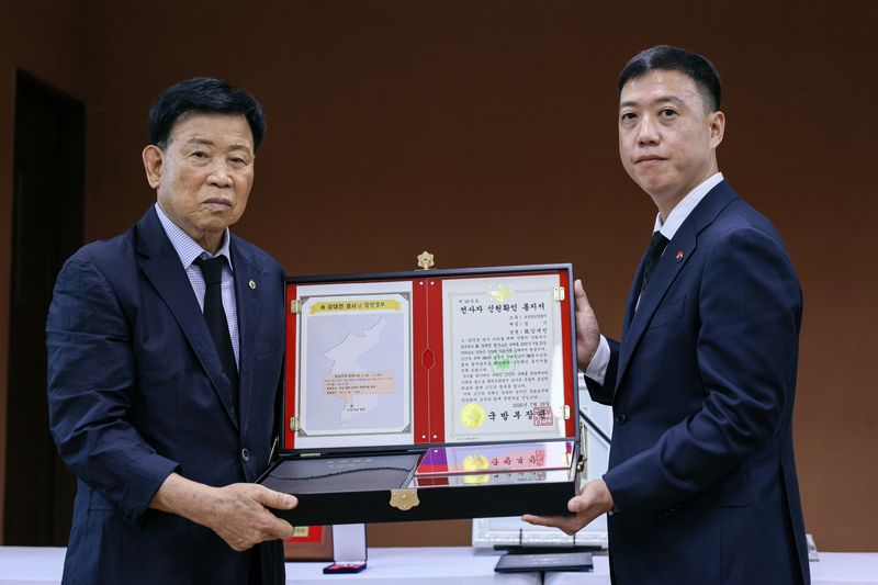 29일 오전 광양시에서 열린 고 강대언 경사 '호국의 영웅 귀환 행사'에서 김성환 국방부 유해발굴감식단장 직무대리가 고인의 동생 강대유 씨(83세)에게 호국의 얼 함을 전달하고 있다. 국방부 제공