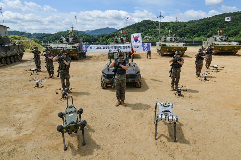 29일 강원 홍천 11기동사단 철마부대에서 개최된 유무인복합분대 실증부대 출범식에서 장병들이 다족형로봇, 드론 등 무인체계와 함께 도열해 경례하는 모습. 육군 제공