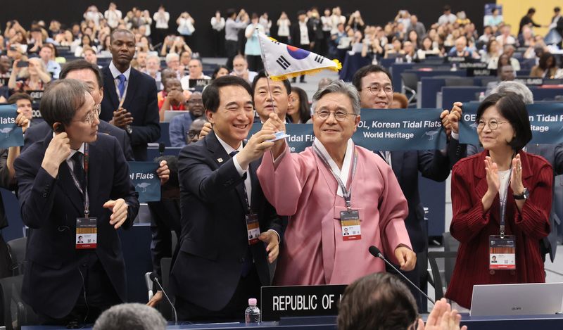 이길용 전남광주 문화정책관(왼쪽부터), 박수현 충남도지사, 허민 국가유산청장, 김지희 주유네스코 대사가 25일 부산 해운대구 벡스코에서 열린 제48차 유네스코 세계유산위원회 본회의에서 한국의 갯벌 2단계 등재가 결정되자 태극기를 흔들며 기쁨을 나누고 있다. 2026.7.25 ⓒ 뉴스1 부산사진공동취재단