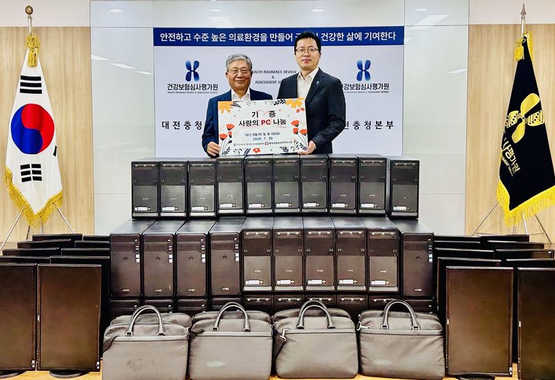 한국사회복지정책연구원 김정우 본부장(왼쪽)과 건강보험심사평가원 대전충청본부 이경수 본부장이 '사랑의 PC' 기증식에서 기념촬영을 하고 있다. 건강보험심사평가원 제공