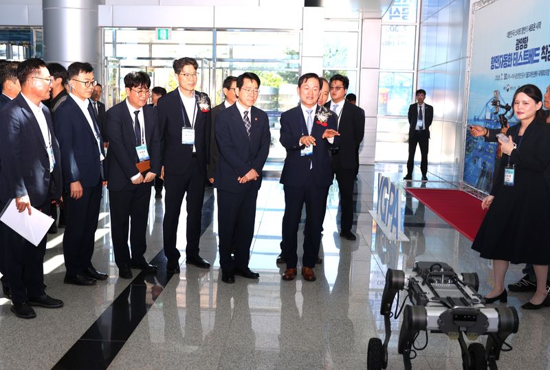 [광양=뉴시스] 30일 광양항 여수광양항만공사(YGPA) 에서 '광양항 항만자동화 테스트베드 구축 사업' 착공식이 열린 가운데 최관호 공사 사장이 황종우 해양수산부 장관에게 로봇개를 설명하고 있다. (사진=YGPA 제공) 2026.07.30. photo@newsis.com *재판매 및 DB 금지