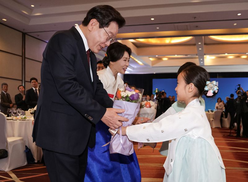 이재명 대통령과 김혜경 여사가 29일(현지시간) 칠레 산티아고 한 호텔에서 열린 동포 만찬간담회에서 화동들에게 꽃다발을 전달 받고 있다. 뉴스1