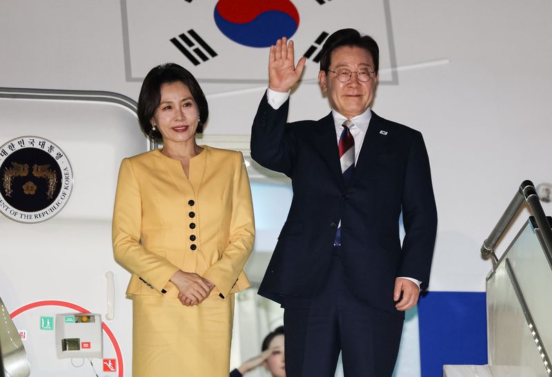 이재명 대통령과 김혜경 여사가 30일(현지시간) 칠레 산티아고 아르투로 메리노 베니테스 공항에서 환송객들에게 인사를 하고 있다. 뉴스1