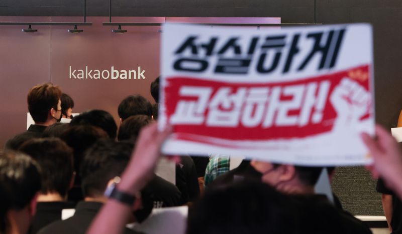 [성남=뉴시스] 김명년 기자 = 민주노총 화섬식품노조 카카오지회 조합원들이 21일 카카오뱅크가 입주한 경기 성남시 판교테크원에서 사측의 임금 인상률과 성과급 등 보상 체계를 규탄하는 피켓 시위를 하고 있다. 2026.07.21. kmn@newsis.com