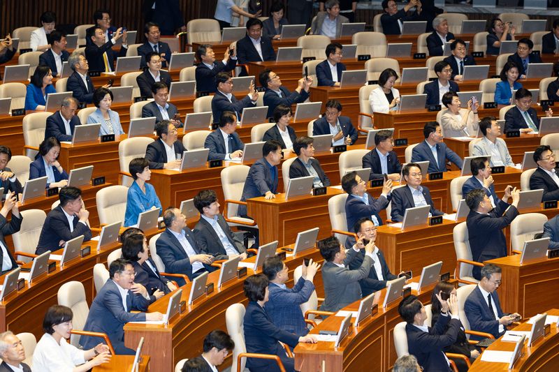 31일 서울 여의도 국회에서 열린 제437회 국회(임시회) 제3차 본회의에서 형사소송법 일부개정법률안(대안)이 재석 178인 중 찬성 175인, 반대 2인으로 가결되자 여당 의원들이 휴대전화로 본회의장 전광판을 촬영하고 있다. 뉴스1