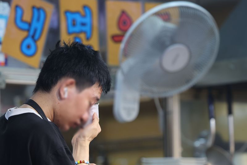 기록적인 폭염이 이어지고 있는 지난 7월 31일 서울 마포구 망원시장에서 시장 상인이 흐르는 땀을 닦고 있다. 뉴시스