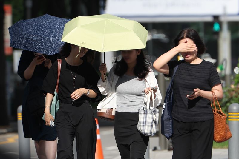 [서울=뉴시스] 김명년 기자 = 무더위가 이어진 지난 29일 서울 중구 세종대로 사거리에서 시민이 손으로 햇볕을 가리며 이동하고 있다. 2026.07.29. kmn@newsis.com