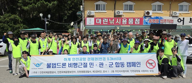 인천공항 인근 해수욕장에서 지난 7월 30일 진행된 '민·관·군 합동 하계 공항지역 불법드론 비행금지 안내 캠페인' 참석자들이 기념촬영을 하고 있다. 인천국제공항공사 제공
