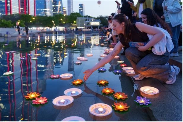 지난 5월 '서울스프링페스티벌'가 열린 영등포구 여의도물빛광장 촛불정원에서 외국인 관광객이 연등을 밝히고 있다. 서울시 제공
