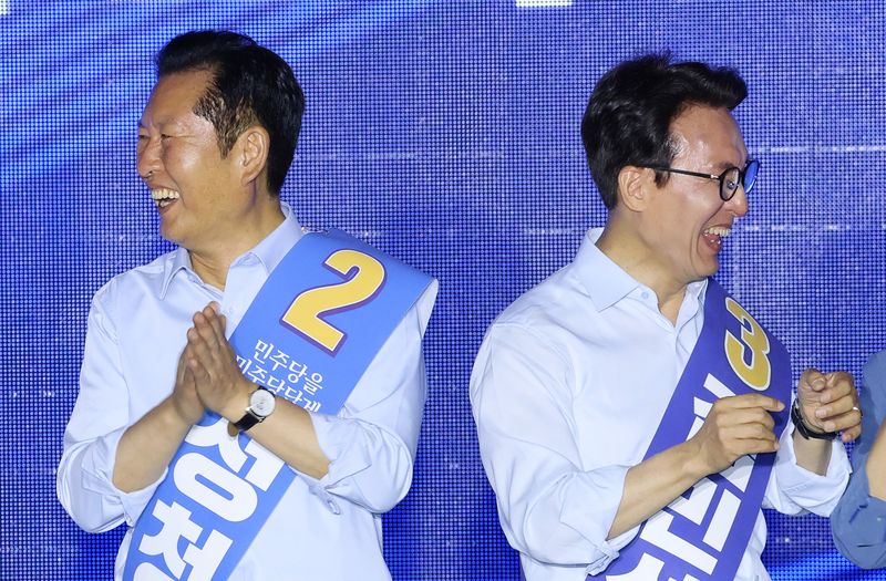 더불어민주당 당권 주자인 정청래(왼쪽), 김민석 의원이 2일 부산 벡스코에서 열린 당대표·최고위원 합동연설회에서 서로 다른 편을 쳐다보고 있다. 연합뉴스