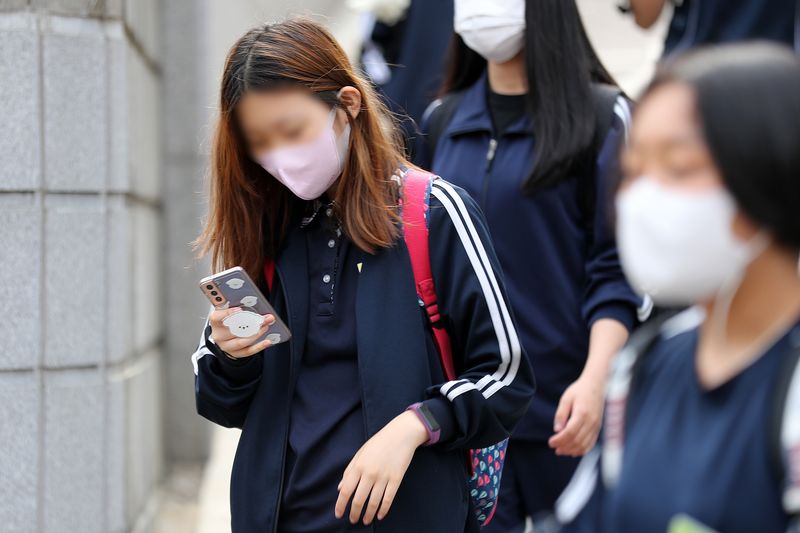[서울=뉴시스] 백동현 기자 = 25일 오후 서울 시내 한 중학교 앞에서 학생들이 스마트폰을 보면서 하교하고 있다. 2022.05.25. livertrent@newsis.com
