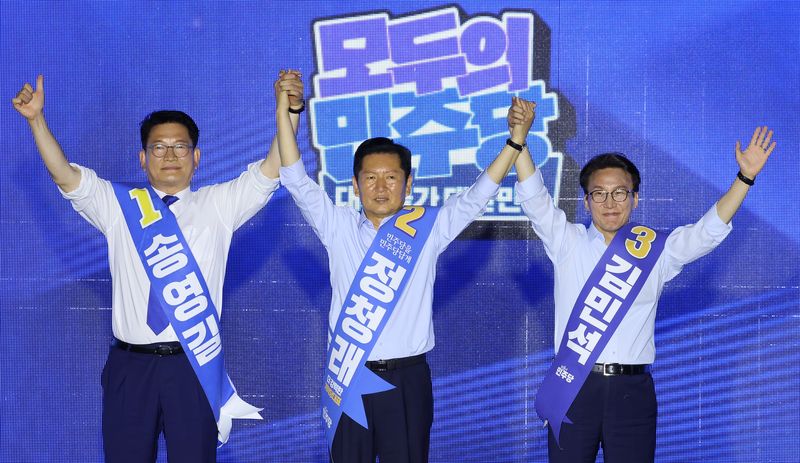 송영길(왼쪽부터), 정청래, 김민석 당 대표 후보가 2일 부산 벡스코에서 열린 더불어민주당 당대표·최고위원 순회경선 합동연설회에서 손을 맞잡고 있다. 연합뉴스