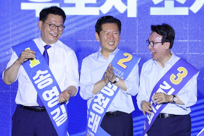 더불어민주당 당권 주자인 송영길, 정청래, 김민석 의원이 2일 부산 벡스코에서 열린 당대표·최고위원 합동연설회에서 손을 맞잡고 있다. 뉴스1