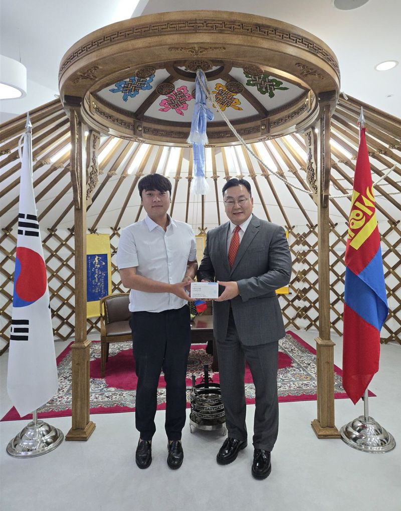 지난달 말 와이즈바이오 김동연 대표(왼쪽)가 주부산몽골영사관을 찾아 차강 웁궁 자담바 영사와 면담한 뒤 자사의 식중독균 검사를 위한 신속 분자진단 키트 ‘위지’를 함께 들고 기념촬영하고 있다. 와이즈바이오 제공
