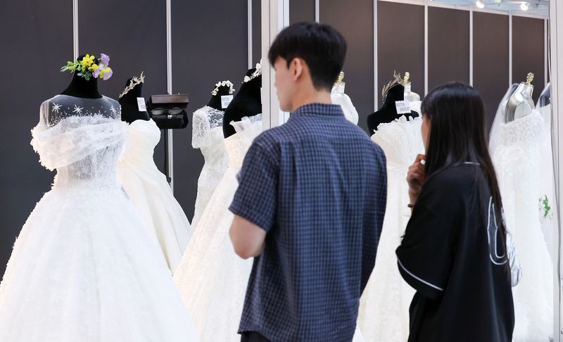6일 서울 강남구 삼성동 코엑스에서 열린 2025 추계 웨덱스 웨딩 박람회에서 예비 부부들이 전시된 드레스를 살펴보고 있다. 2025.7.6 ⓒ 뉴스1 김성진 기자