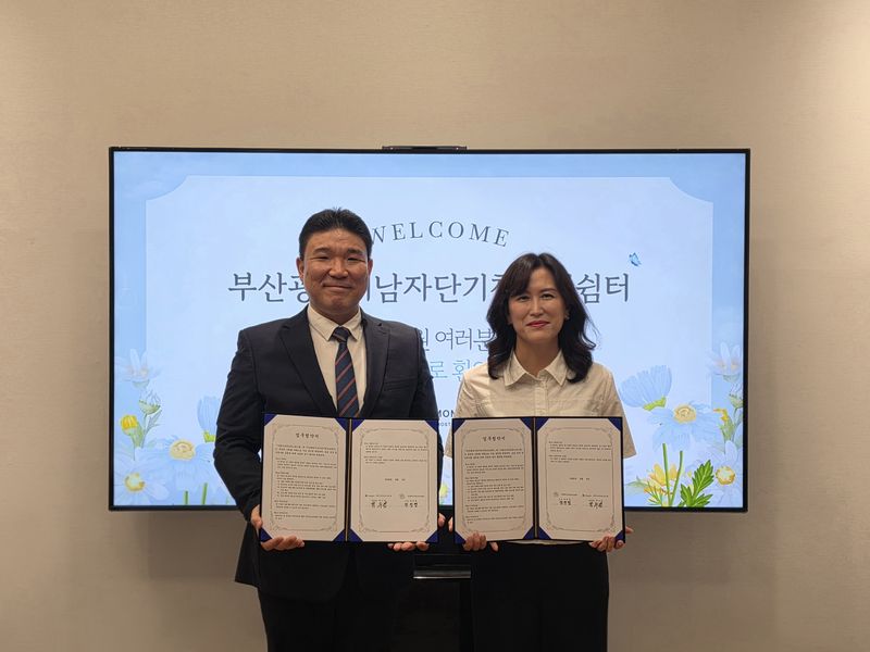 그랜드모먼트 유스호스텔 박수영 운영대표(왼쪽)와 부산광역시남자단기청소년쉼터 전선영 소장이 업무협약서를 들고 포즈를 취하고 있다. 그랜드모먼트 유스호스텔 제공