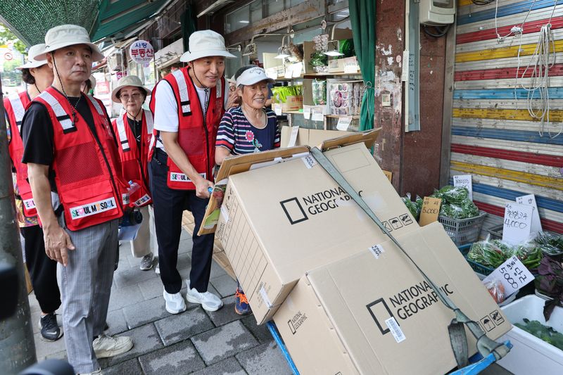 [서울=뉴시스] 김금보 기자 = 오세훈 서울시장이 4일 서울 용산구 효창동 일대 골목에서 폐지 수집 어르신을 도와 손수레를 밀고 있다. 2026.08.04. kgb@newsis.com