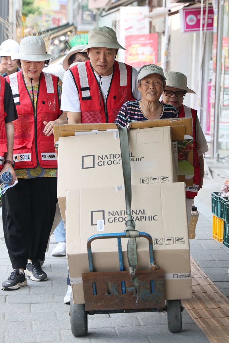 [서울=뉴시스] 김금보 기자 = 오세훈 서울시장이 4일 서울 용산구 효창동 일대 골목에서 폐지 수집 어르신을 도와 손수레를 밀고 있다. 2026.08.04. kgb@newsis.com