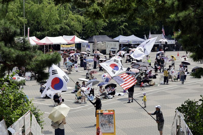 [서울=뉴시스] 최동준 기자 = 투표용지 부족 사태에 항의하는 개표소 시위가 54일째 이어지고 있는 지난달 28일 서울 송파구 올림픽공원 핸드볼 경기장 앞에서 시위 참가자들이 구호를 외치고 있다. 2026.07.28. photocdj@newsis.com
