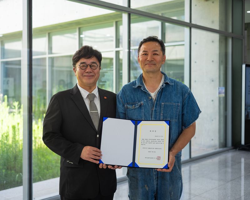 이종후 제주도립미술관장(왼쪽)이 김창옥 김창옥아카데미 대표에게 ‘2026 제5회 제주비엔날레’ 홍보대사 위촉장을 전달한 뒤 기념촬영하고 있다. 김 대표는 메인 홍보영상과 강연, 특별 도슨트, 공식 행사 등에 참여한다. /사진=제주비엔날레 사무국 제공