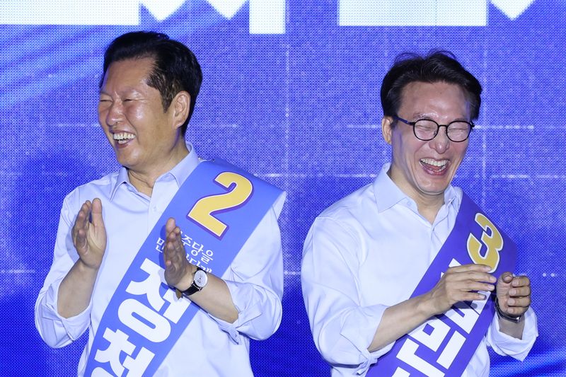 더불어민주당 당권 주자인 정청래(왼쪽), 김민석 의원이 지난 2일 부산 벡스코에서 열린 당대표·최고위원 합동연설회에서 미소짓고 있다. 2026.8.2 ⓒ 뉴스1 신웅수 기자