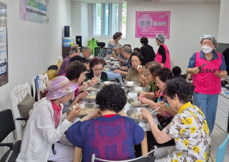 행복봉사단 단원과 자원봉사자들이 지난달 25일 서울 서초구 우면동 네이처힐 6단지 경로당에서 어르신들에게 중복 맞이 삼계탕을 대접하고 있다. 행복봉사단 제공