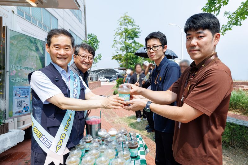 김범호 인천국제공항공사 사장직무대행(앞줄 왼쪽)이 지난 4일 '찾아가는 인천공항 아이스 데이' 행사에서 항공물류 현장 근무자에게 음료를 전달하고 있다. 인천국제공항공사 제공