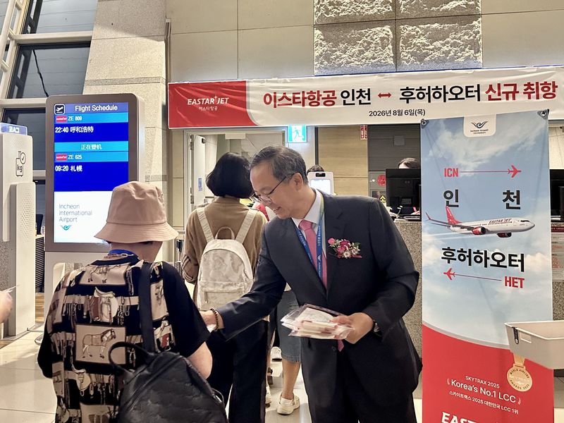 조중석 이스타항공 대표(앞줄 오른쪽)가 지난 6일 인천∼후허하오터 취항식뒤 첫 편 승객들에게 기념 선물을 나눠주고 있다. 이스타항공 제공