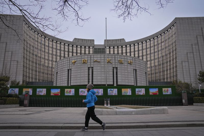 [베이징=AP/뉴시스] 2024년 2월20일 중국 베이징의 중국인민은행 앞을 한 여성이 달리고 있다. 2024.02.20.