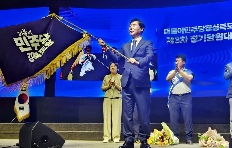 9일 대구 북구 산격동 인터불고 엑스코 호텔에서 열린 더불어민주당 경북도당 정기당원대회에서 차기 도당 위원장으로 선출된 오중기 후보가 민주당 경북도당 당기를 흔들고 있다. ⓒ 뉴스1 남승렬 기자