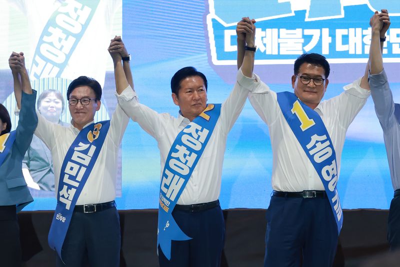 더불어민주당 김민석(왼쪽부터)·정청래·송영길 당 대표 후보가 9일 강원도 횡성국민체육센터에서 열린 민주당 대표·최고위원 후보자 강원 합동연설회에서 손을 잡고 기념 촬영하고 있다. 연합뉴스