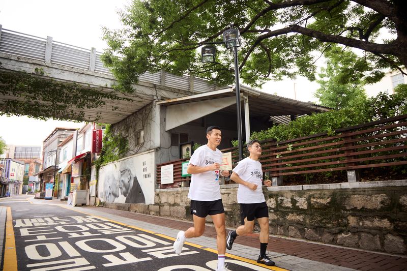 정재헌 SK텔레콤 대표(오른쪽)와 가수 션이 최근 종로구에 조성된 '독립을 이끈 여성들을 기억하길' 코스를 함께 달리고 있다. SK텔레콤 제공