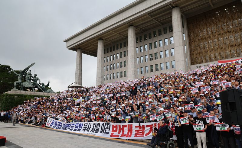 육·해·공군 사관학교 총동창회 등 참석자들이 8일 서울 여의도 국회 본관 앞에서 사관학교 통합 반대 총궐기대회를 하고 있다. 뉴시스