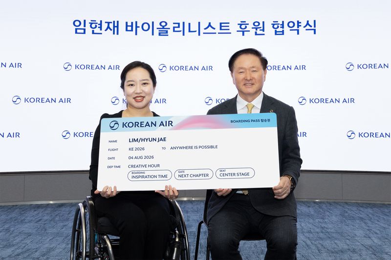 우기홍 대한항공 부회장(오른쪽)이 최근 서울 강서구 대한항공 본사에서 임현재 바이올리니스트 후원 협약을 맺은 뒤 모형항공권을 들고 기념촬영을 하고 있다. 대한항공 제공