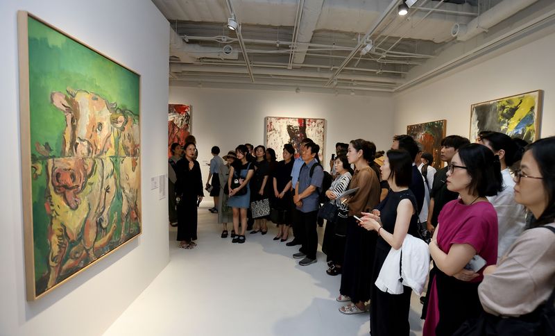 지난 12일 서울 종로구 세화미술관에서 열린 '게오르그 바젤리츠' 회고전 개막식에서 참석자들이 게오르그 바젤리츠의 '나뉜 소 두 마리Ⅰ'을 감상하고 있다. 태광그룹 제공