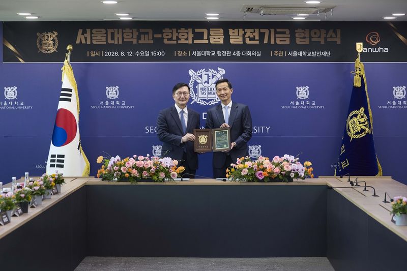 유홍림 서울대 총장(왼쪽)이 지난 12일 서울대 관악캠퍼스에서 김동관 한화그룹 수석부회장에게 감사패를 전달한 뒤 기념촬영을 하고 있다. 서울대 제공