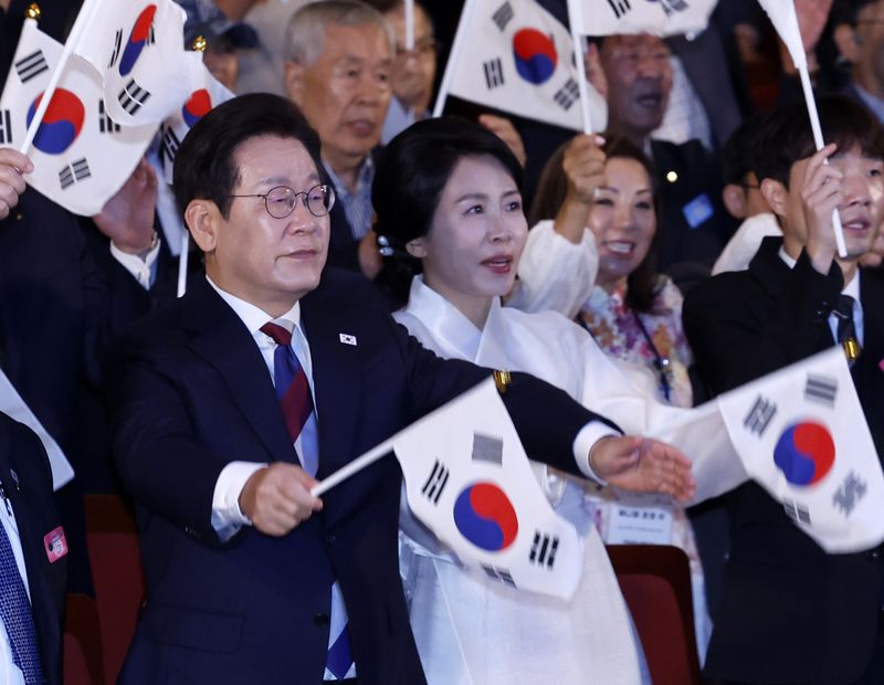 [서울=뉴시스] 최동준 기자 = 이재명 대통령과 김혜경 여사가 15일 서울 종로구 세종문화회관에서 열린 제80주년 광복절 경축식에서 참석자들과 태극기를 흔들고 있다. 2025.08.15. photocdj@newsis.com