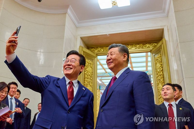 이재명 대통령과 시진핑 국가주석이 지난 1월 중국 베이징 인민대회당에서 국빈만찬 후 샤오미폰으로 기념촬영을 하고 있다.연합뉴스