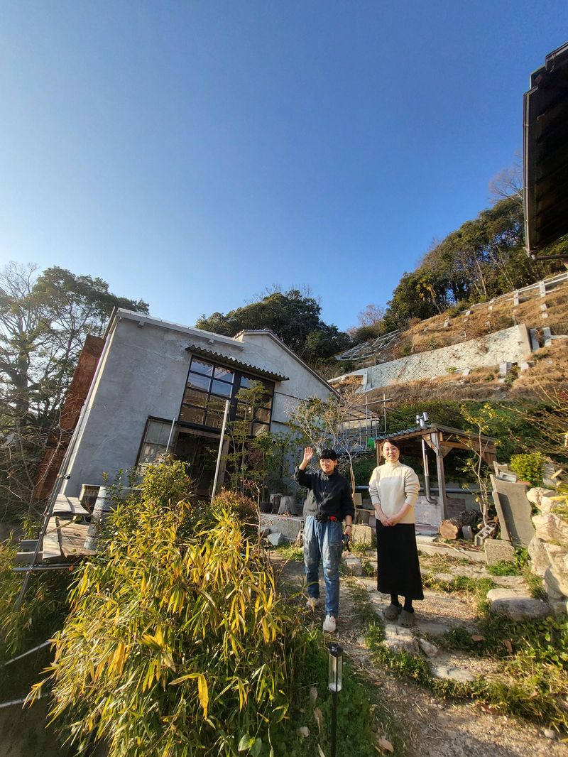 빈집을 커뮤니티 공간으로 개조한 일본 효고현 고베시 효고구 산노초 다니아파트와 고주택 '아이코야'가 마주보고 있는 길목에서 다니아파트의 개보수에 참여한 하이오쿠 유한책임회사(LLC)의 미야케 요코(왼쪽)와 '아이코야'의 집주인 무라카와 아이코가 인사하고 있다.