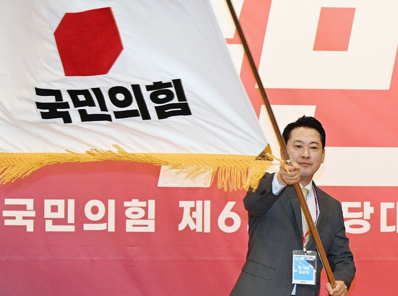 장동혁 국민의힘 당대표가 2025년 8월 26일 오전 서울 여의도 국회 도서관에서 열린 제6차 전당대회 결선에서 당대표로 당선된 뒤 당기를 흔들고 있다. 2025.8.26 ⓒ 뉴스1 국회사진기자단