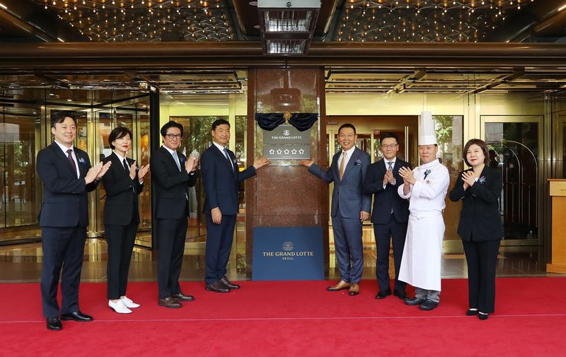 정호석(왼쪽에서 네번째) 롯데호텔 대표이사를 비롯한 주요 임직원들이 지난 14일 서울 중구 더그랜드롯데 서울에서 열린 현판 제막식에서 기념촬영을 하고 있다. 롯데호텔앤리조트 제공