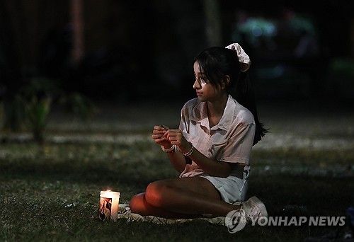 지진 희생자들을 위한 추모식에 참석한 한 여성 (출처=연합뉴스)